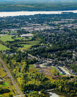 Aerial view of Brockville, Ontario bordered by train tracks and the St. Lawrence River with New York State in the distance